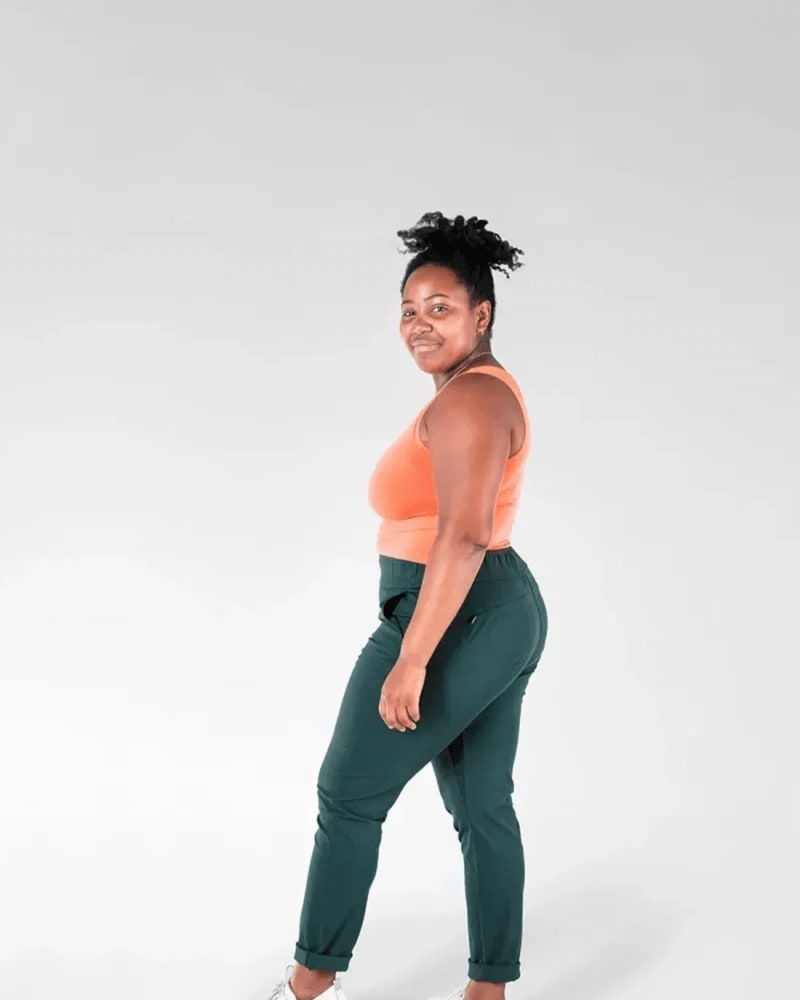 Back of a model wearing a size 4X open air pant (32") in forest green by alder apparel. | dia_product_style_image_id:301324